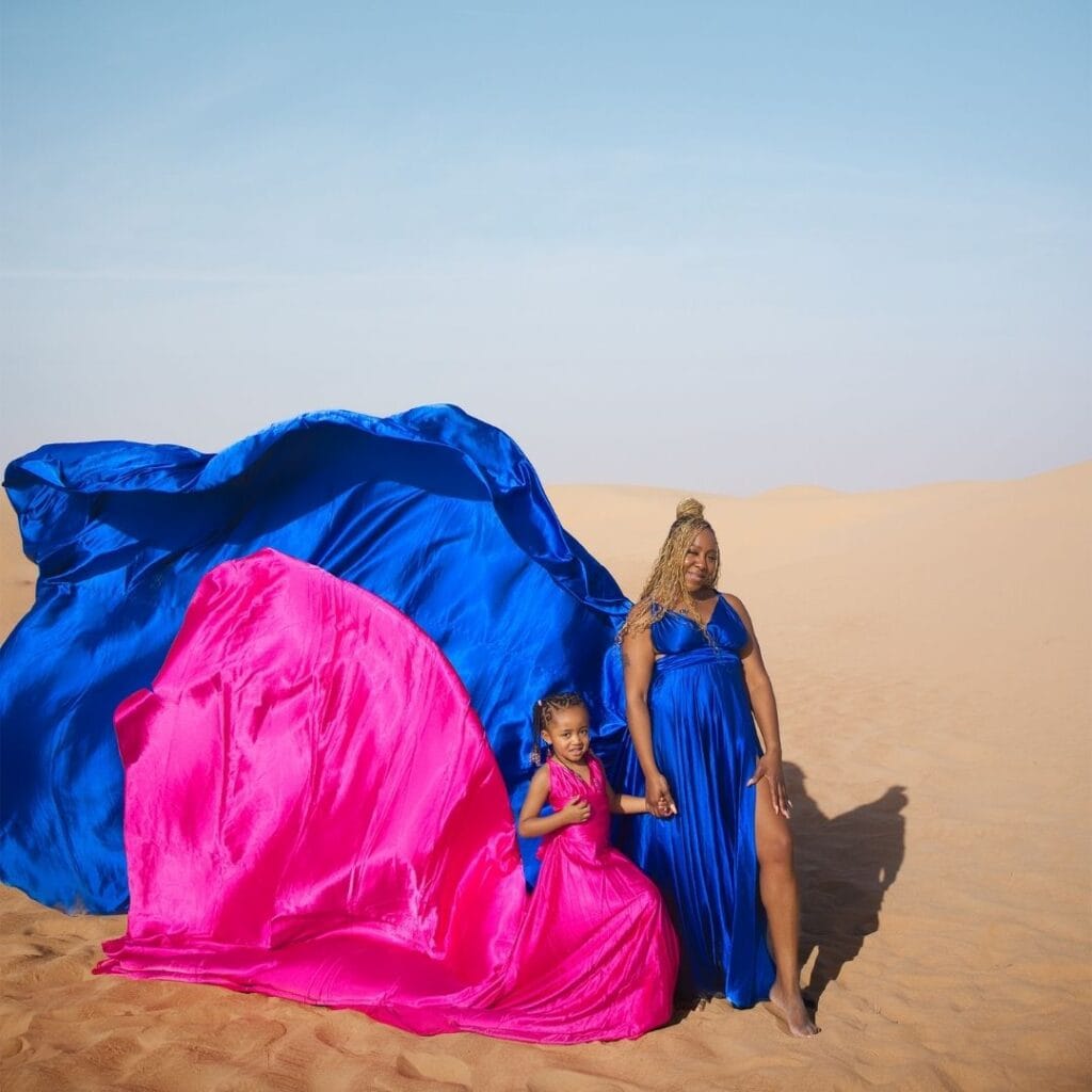 Couple flying dress photoshoot in Dubai desert with blue and pink flowing dresses and luxury professional photography experience