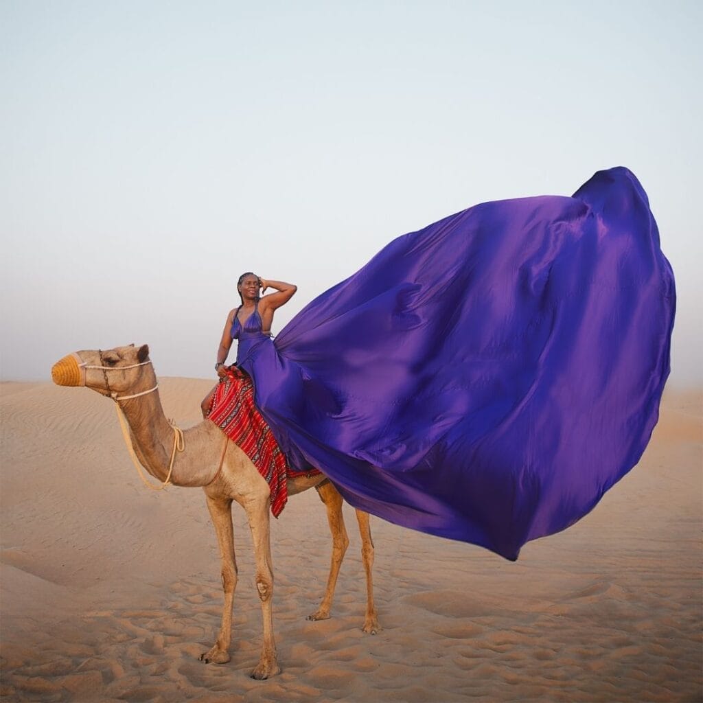 Purple flying dress photoshoot in Dubai desert with camel and luxury professional photography experience