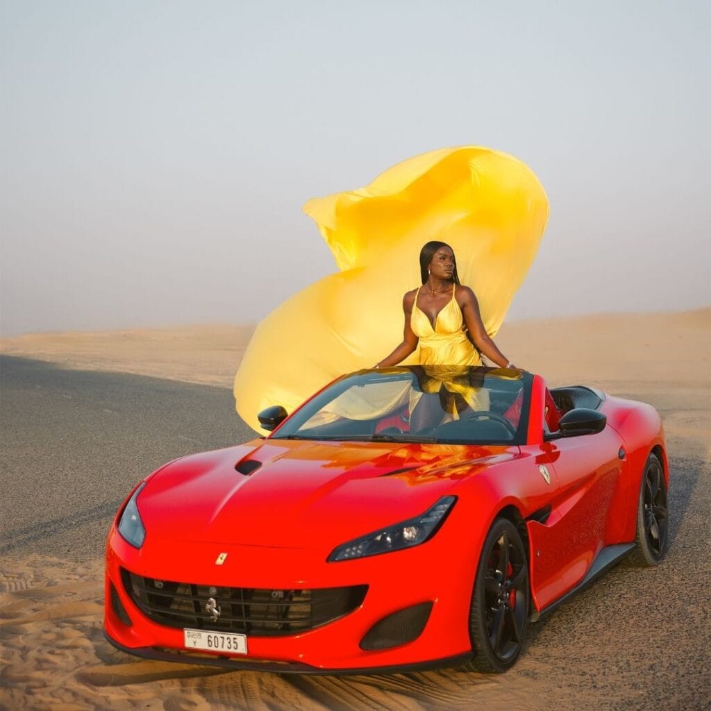 Yellow flying dress photoshoot in Dubai desert with luxury car and premium professional photography experience