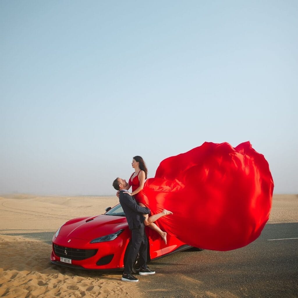 Luxury car red flying dress photoshoot in Dubai desert with premium professional photography experience