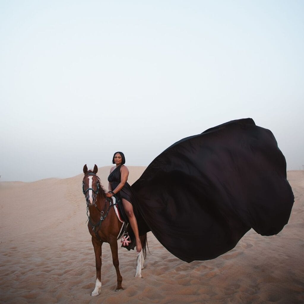 Black flying dress photoshoot in Dubai desert with horse and luxury professional photography experience